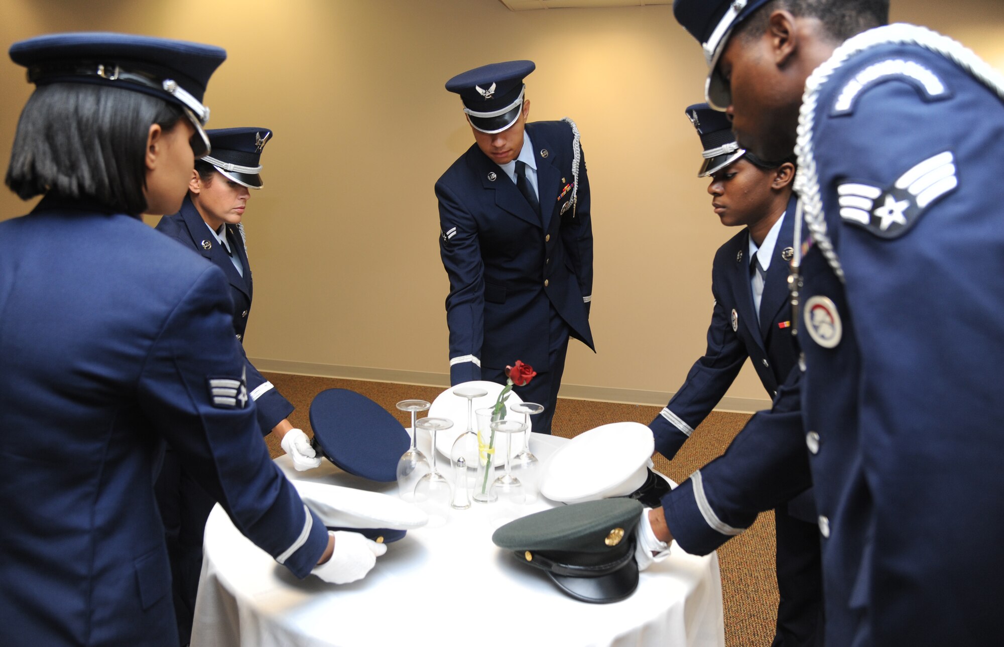 Senior Airman Valarie Chalys, Tech. Sgt. Kristy Crespo, Airmen 1st Class Erik Taylor and Shade Bennett, and Senior Airman Carlton Best, Keesler Honor Guard members, place service hats on a prisoner of war/missing in action ceremonial table during a training session June 26, 2013, at the Locker House, Keesler Air Force Base, Miss.  The Keesler Honor Guard’s primary mission is to render military honors for our nation’s fallen service members.  They also support other ceremonial functions such as saber/sword cordons, parades, posting of the colors at retirements, change of commands, prisoner of war/missing in action honors, weddings, sporting events and venues within the local community.  (U.S. Air Force photo by Kemberly Groue)