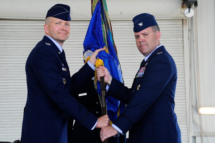 (Left) Col. Darren Hartford, 437th Airlift Wing commander, hands the 437th Operations Group guidon to Col. Fred Boehm (right) during the 437th OG change of command ceremony June 27, 2013, in Nose Dock 2 at Joint Base Charleston – Air Base, S.C. Boehm took command from Col. Trevor Nitz. (U.S. Air Force photo/Staff Sgt. Rasheen Douglas)