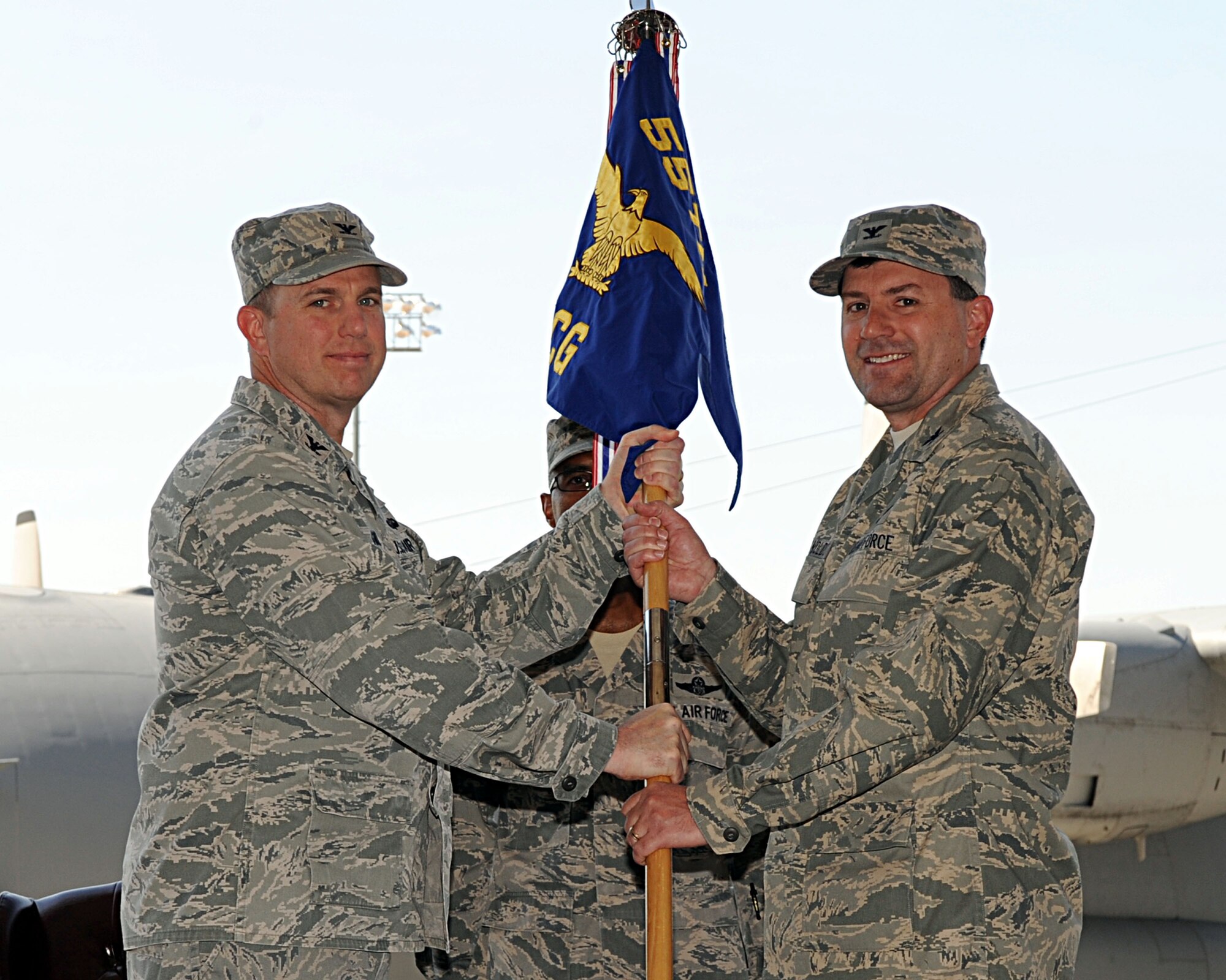 U.S. Air Force Col. George Reynolds (right) takes the guidon from Col. Gregory Guillot, 55th Wing commander, as he assumes command of the 55th Electronic Combat Group June 27 at Davis-Monthan Air Force Base, Ariz.. As commander of the 55th ECG, Reynolds is responsible for organizing, training and equipping five squadrons of more than 900 Airmen to provide combat-ready EC-130H Compass Call aircraft, aircrew and maintainers for worldwide expeditionary deployment in support of unified combatant commanders. (U.S. Air Force photo by Senior Airman Timothy Moore/Released)