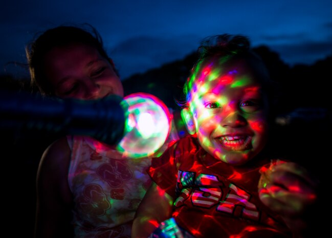 Military dependents play with a light stick June 28, during the 2013 Freedom Fest at Marrington Plantation at Joint Base Charleston – Weapons Station, S.C. Nearly 1,500 Airmen, Sailors, civilians and their families attended the celebration which included food, drinks, festival rides, music and fireworks. (U.S. Air Force photo/ Senior Airman Dennis Sloan)