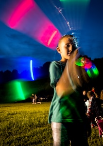 A military dependent twirls a light stick June 28, during the 2013 Freedom Fest at Marrington Plantation at Joint Base Charleston – Weapons Station, S.C. Nearly 1,500 Airmen, Sailors, civilians and their families attended the celebration which included food, drinks, festival rides, music and fireworks. (U.S. Air Force photo/ Senior Airman Dennis Sloan)