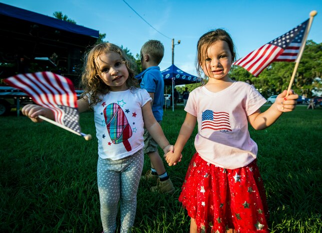 Two Air Force dependents carry American flags June 28, during the 2013 Freedom Fest at Marrington Plantation at Joint Base Charleston – Weapons Station, S.C. Nearly 1,500 Airmen, Sailors, civilians and their families attended the celebration which included food, drinks, festival rides, music and fireworks. (U.S. Air Force photo/ Senior Airman Dennis Sloan)