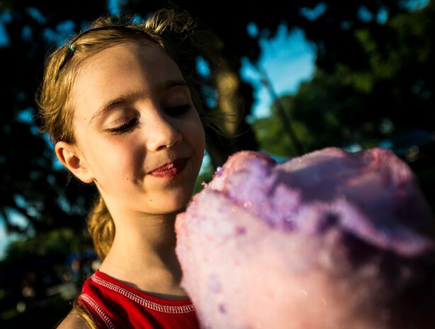 A military dependent eats cotton candy June 28, during the 2013 Freedom Fest at Marrington Plantation at Joint Base Charleston – Air Base, S.C. Nearly 1,500 Airmen, Sailors, civilians and their families attended the celebration which included food, drinks, festival rides, music and fireworks. (U.S. Air Force photo/ Senior Airman Dennis Sloan)