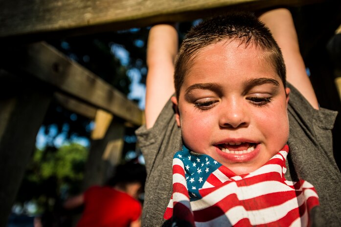 An Air Force military dependent plays on monkey bars during the 2013 Freedom Fest at Marrington Plantation, June 28,  at Joint Base Charleston – Weapons Station, S.C. Nearly 1,500 Airmen, Sailors, civilians and their families attended the celebration which included food, drinks, festival rides, music and fireworks. (U.S. Air Force photo/ Senior Airman Dennis Sloan)