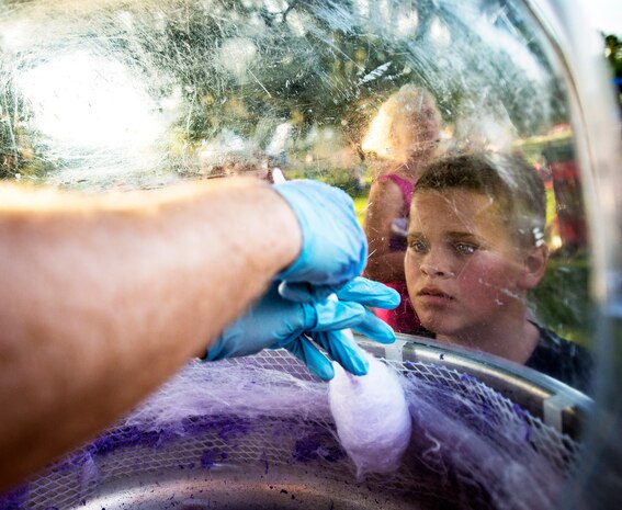 An Air Force military dependent watches a volunteer make cotton candy June 28, during the 2013 Freedom Fest at Marrington Plantation at Joint Base Charleston – Air Base, S.C. Nearly 1,500 Airmen, Sailors, civilians and their families attended the celebration which included food, drinks, festival rides, music and fireworks. (U.S. Air Force photo/ Senior Airman Dennis Sloan)