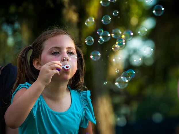 Jenna Calafiore, daughter of Jeff Calafiore, Zero to Never band member, blows bubbles, during the 2013 Freedom Fest June 28, at Marrington Plantation at Joint Base Charleston – Weapons Station, S.C. Nearly 1,500 Airmen, Sailors, civilians and their families attended the celebration which included food, drinks, festival rides, music and fireworks. (U.S. Air Force photo/ Senior Airman Dennis Sloan)