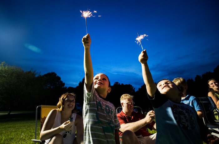 Waylon Fullmer, son of Chief Petty Officer Bruce Fullmer, a machinist’s mate at Naval Nuclear Power Training Command,  and Ryan Pefley, son of Chief Petty Officer David Pefley, a machinist’s mate at the Naval Nuclear Power Training Command, hold their sparklers high June 28, during the 2013 Freedom Fest at Marrington Plantation at Joint Base Charleston – Weapons Station, S.C. Nearly 1,500 Airmen, Sailors, civilians and their families attended the celebration which included food, drinks, festival rides, music and fireworks. (U.S. Air Force photo/ Senior Airman George Goslin)