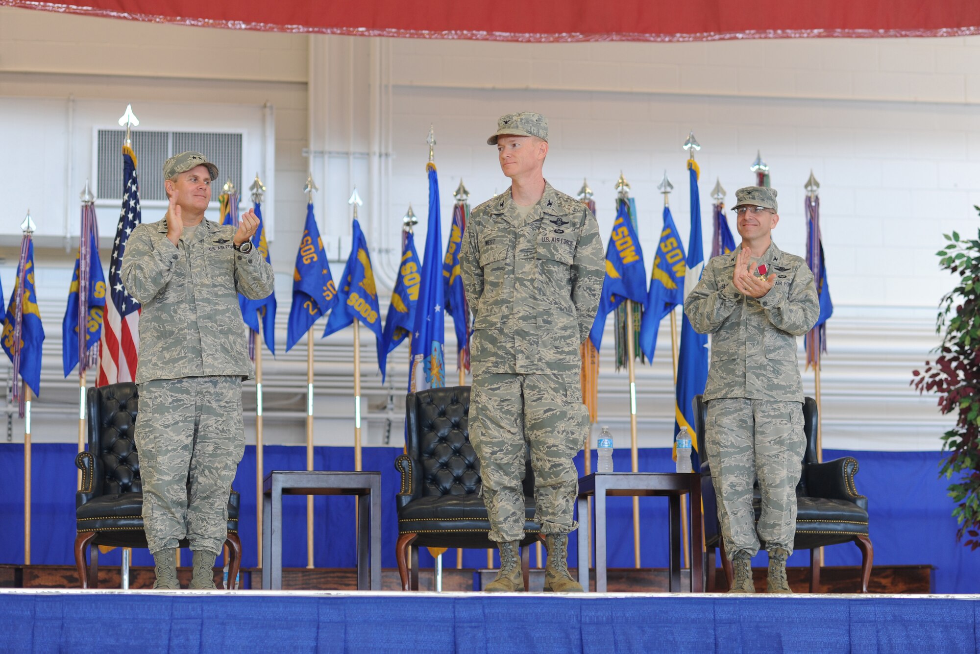 Col. William West, middle, commander of the 1st Special Operations Wing, is welcomed to Team Hurlburt, during the change of command ceremony at the Freedom Hangar on Hurlburt Field, Fla., July 3, 2013. West assumed command from Col. Jim Slife, right, the outgoing commander. (U.S. Air Force photo by Senior Airman Kentavist P. Brackin) 