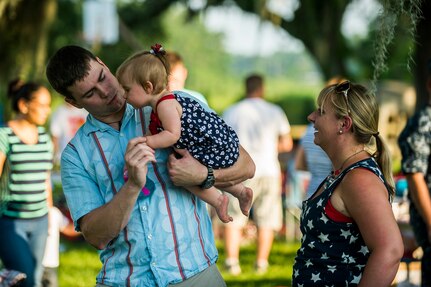 Petty Officer 2nd Class Richard Smith, an electrician’s mate at the Nuclear Power Training Unit, dances with his daughter, Lyla and his wife Lauren June 28, during the 2013 Freedom Fest at Marrington Plantation at Joint Base Charleston – Weapons Station, S.C. Nearly 1,500 Airmen, Sailors, civilians and their families attended the celebration which included food, drinks, festival rides, music and fireworks. (U.S. Air Force photo/ Senior Airman George Goslin)