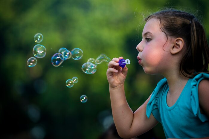 Jenna Calafiore, daughter of Jeff Calafiore, Zero to Never band member, blows bubbles during the 2013 Freedom Fest June 27, at Marrington Plantation at Joint Base Charleston – Weapons Station, S.C. Nearly 1,500 Airmen, Sailors, civilians and their families attended the celebration which included food, drinks, festival rides, music and fireworks. (U.S. Air Force photo/ Senior Airman George Goslin)