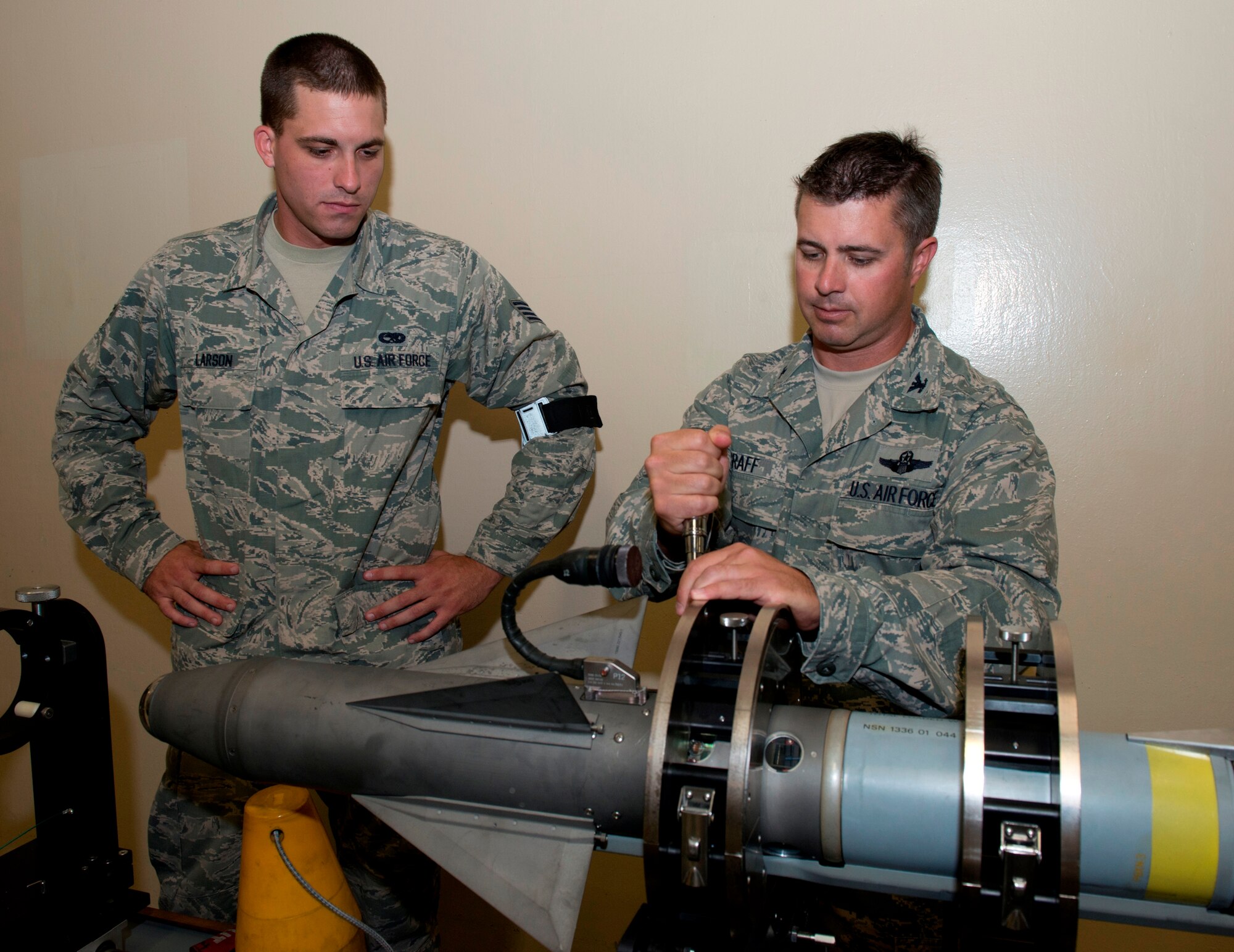 Staff Sgt. Kyle Larson, 325th Maintenance Squadron precision guided munitions crew chief, shows Colonel David E. Graff, 325th Fighter Wing commander, how to apply proper torque techniques to the wing screws during the Airman Shadow program June 27. (U.S. Air Force photo by Lisa Norman) 