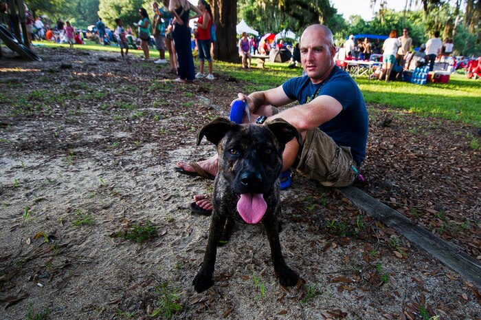 Marine Corps Staff Sgt. Morgan Bartra, Marine Enlisted Commissioning Program, Naval Reserve Officer Training Corps of The Citadel, sits with his dog Cadence, June 28, during the 2013 Freedom Fest at Marrington Plantation at Joint Base Charleston – Weapons Station, S.C. Nearly 1,500 Airmen, Sailors, civilians and their families attended the celebration which included food, drinks, festival rides, music and fireworks. (U.S. Air Force photo/ Senior Airman George Goslin)