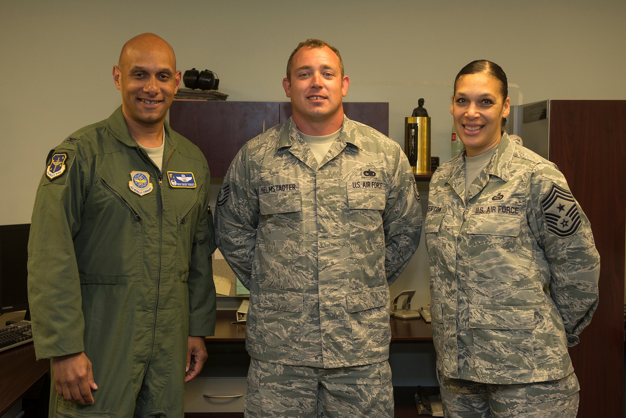 Col. Brian Robinson, 19th Airlift Wing commander, and Chief Master Sgt. Margarita Overton, 19th Airlift Wing command chief, congratulate Tech. Sgt. Patrick Helmstadter, a 19th Maintenance Group quality assurance inspector July 1, 2013, at Little Rock Air Force Base, Ark. Helmstadter, an Aurora, Mo., native, conducts evaluations on over 1,700 technicians within the maintenance group, supporting 56 C-130 aircraft valued at $1.9 billion. (U.S. Air Force photo by Staff Sgt. Russ Scalf)