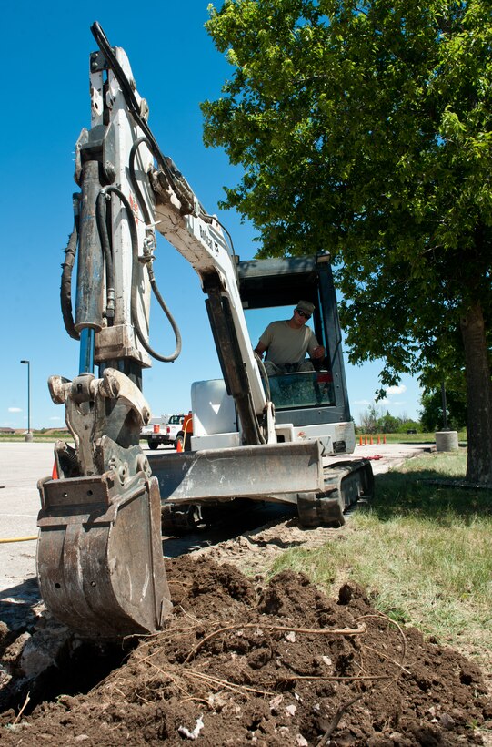 Staff Sgt. Raymond Zgoda, 28th Civil Engineer Squadron heavy equipment and pavement technician, removes a concrete curb during minor repairs in front of the 28th Bomb Wing Headquarters on Ellsworth Air Force Base, S.D., June 27, 2013. After the concrete and pavement are cut, the pieces are removed and the existing hole is then filled in with new concrete before being shaped to make a new, effective curb. (U.S. Air Force photo by Senior Airman Kate Maurer/Released) 
