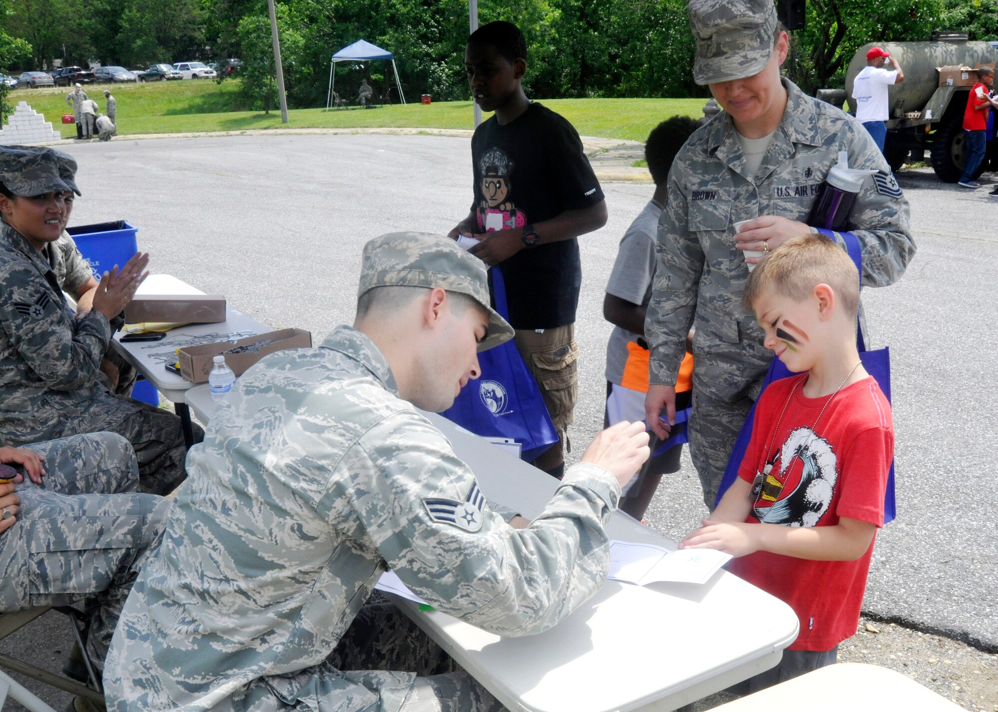 Tech. Sgt. Tracy Brown, 779th Medical Operations Squadron NCO of cardio pulminary services, and her son get their Operation KID Mode deployment passport stamped June 28, 2013 at Joint Base Andrews, Md. Operation KID Mode is a kid-friendly, pretend deployment mobility line designed to help children of service members better understand their parents' actual deployment process. (U.S. Air Force photo/Senior Airman Lindsey A. Porter)