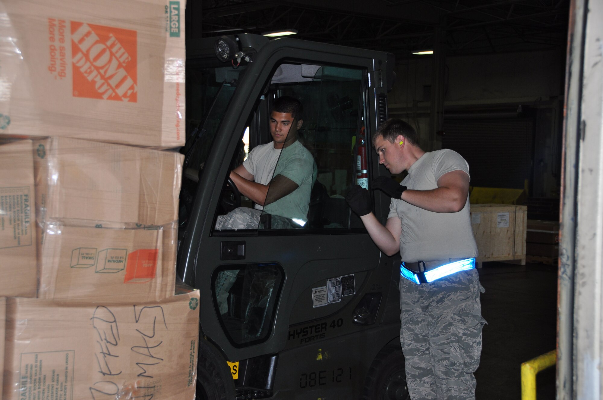 Senior Airman Jacob Peterson guides Airman 1st Class Jacob Siluano, both 60th Aerial Port Squadron air freight operators, as they load supplies donated by the Denton Program June 25 at Travis Air Force Base, Calif. The Denton Program under Title 10, uses empty space on U.S. military transport for transportation of humanitarian relief for nongovernmental organizations or private citizens at little or no cost to them. The latest shipment of supplies will benefit 2,000 Afghans with textiles and food.(U.S. Air Force photo/Staff Sgt. Christopher Carranza)