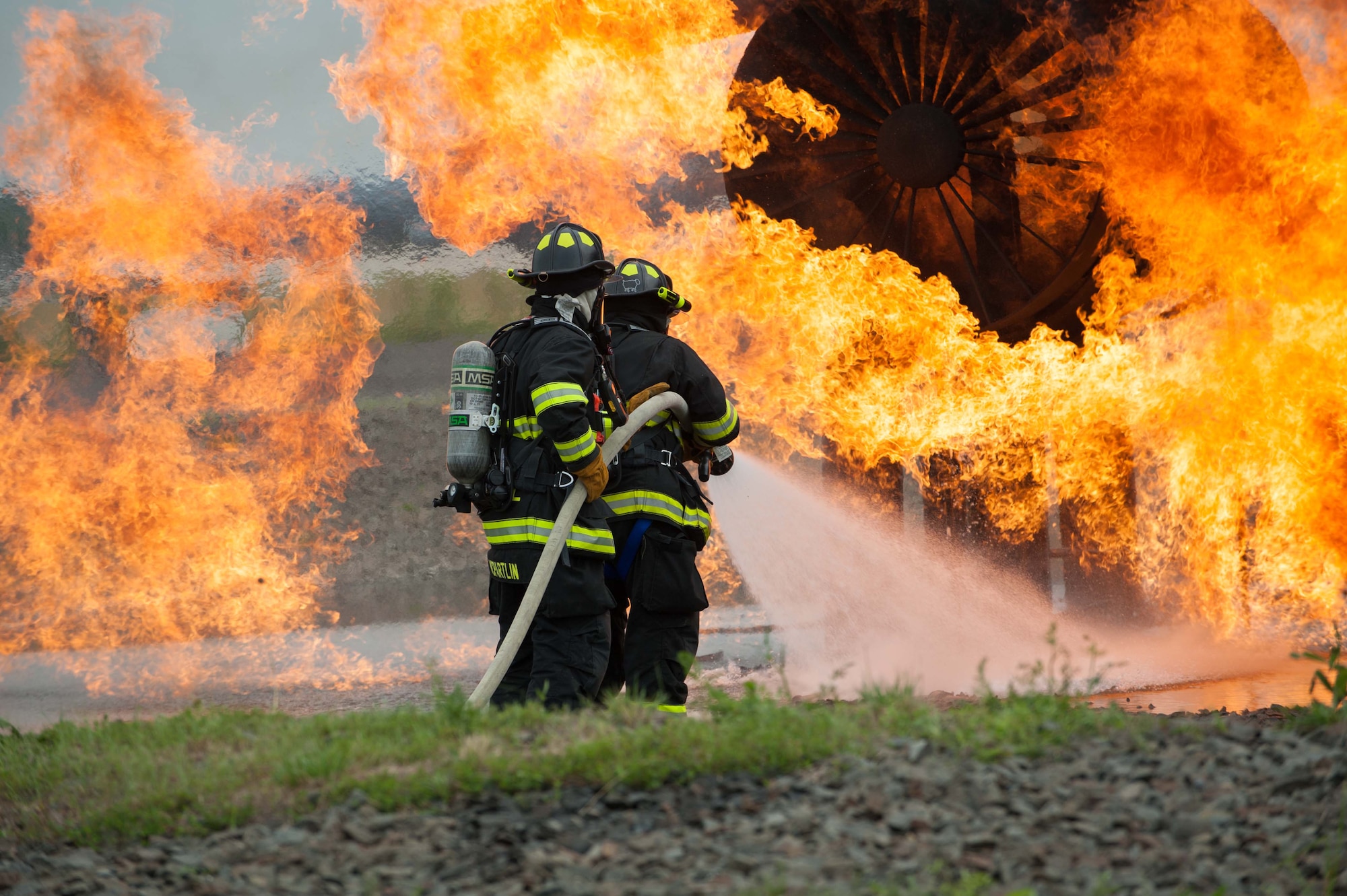 Firefighters from the 87th Civil Engineer Squadron from the extinguish flames from a trainer aircraft during a live fire burn exercise June 18, 2013, at Joint Base McGuire-Dix-Lakehurst, N.J. The firefighters go through the training two times a year to be recertified. (U.S. Air Force photo by Russ Meseroll/Released)