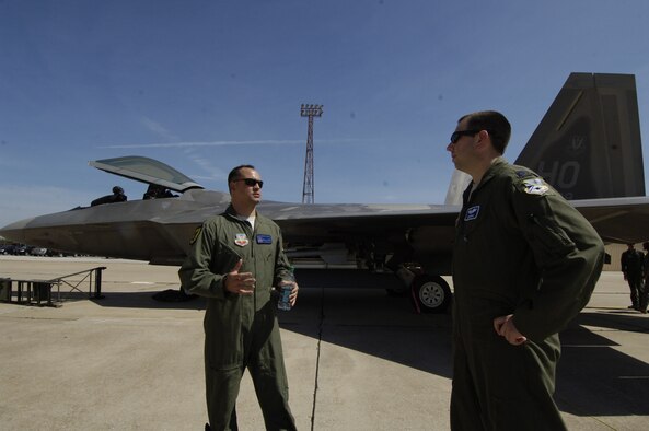Maj. Jason Storevik, a weapons officer from Holloman Air Force Base, N.M., left, talks shop with Capt. Chris Murphy, a weapons officer with the 552nd Operations Support Squadron at Tinker, next to the Air Force’s elite F-22 “Raptor” that Major Storevik flew in on Friday, June 28, along with a couple other crewmembers from Holloman. The crewmembers, who also included Capt. David Ruiz and 1st Lt. Andrew Van Timmeren, flew into Tinker in the F-22 and a T-38 to provide a weapons and tactics talk and discuss possible future employment opportunities with members of the 552nd Air Control Wing, who routinely train with the crews from Holloman, according to Major Storevik. (Air Force photo by Darren D. Heusel)
