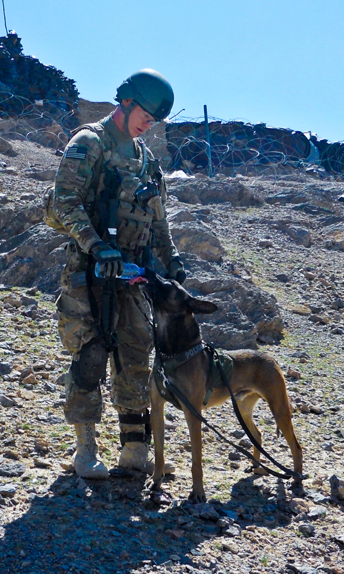Shannon Hutto, 6th Security Forces Squadron dog handler, and Eddie, 6th SFS military working dog, take a drink during a recent deployment. (Courtesy photo)