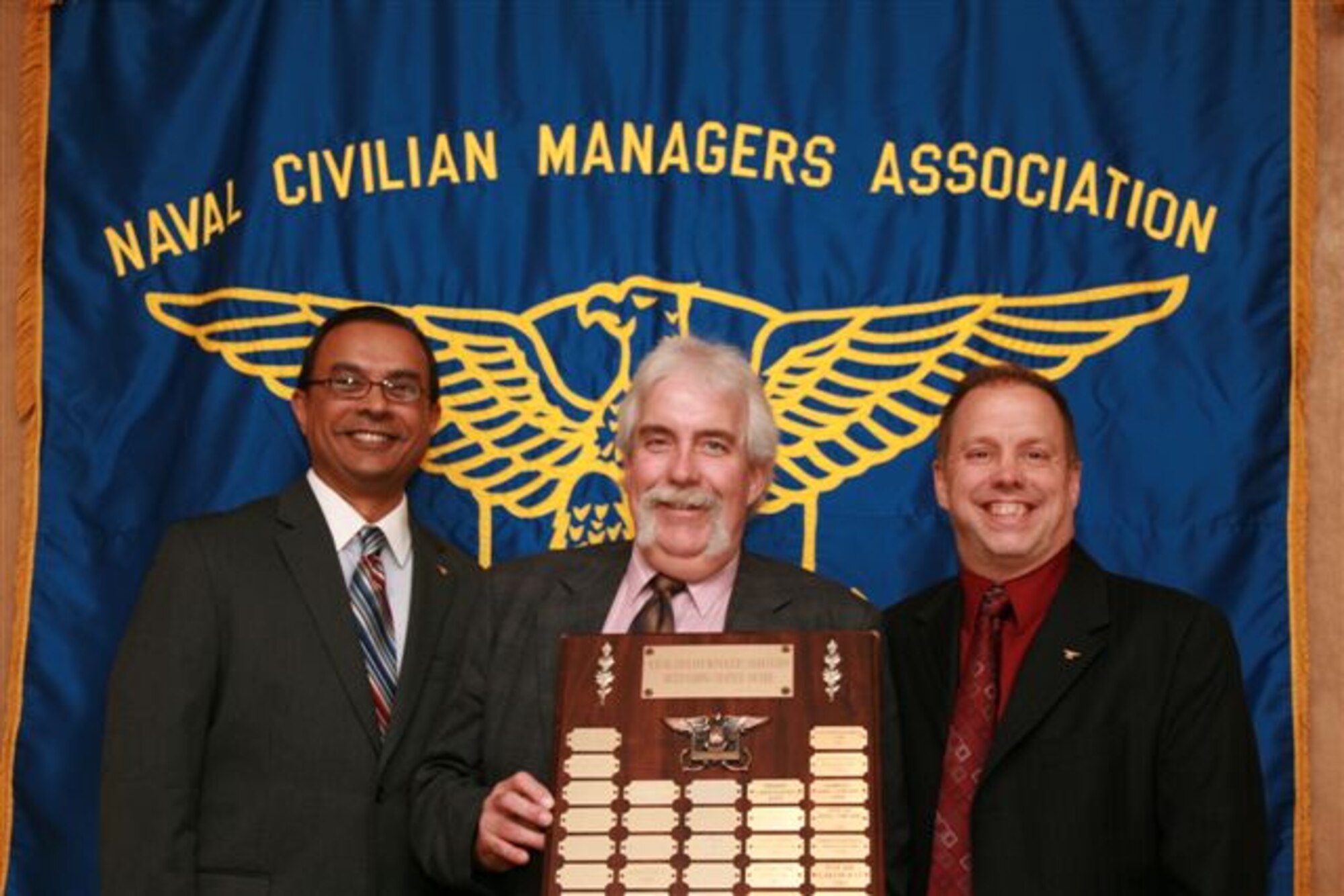 Naval Air Systems Command Lakehurst chapter was honored by being named the nation’s best Naval Civilian Managers Association in Alexandria chapter for the second consecutive year June 26, 2013, at the annual NCMA conference in Virginia. Farhad Choudhury, chapter secretary (left), and John Schmelzle, chapter president (right), receive the award from Scott Butcher, national president.