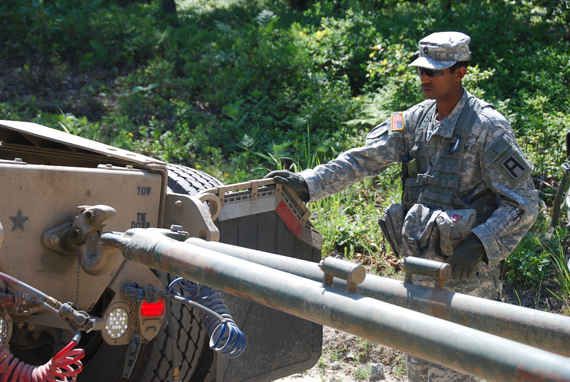 Sgt. 1st Class Panki Miah, 174th Infantry Brigade trainer/mentor, helps a driver guide a tow bar into place during a recovery mission June 21, 2013, at Joint Base McGuire-Dix-Lakehurst, N.J. The training was part of the 78th Training Division’s Combat Support Training Exercise. (U.S. Army photo by Capt. Antonia Greene-Edwards/Released)