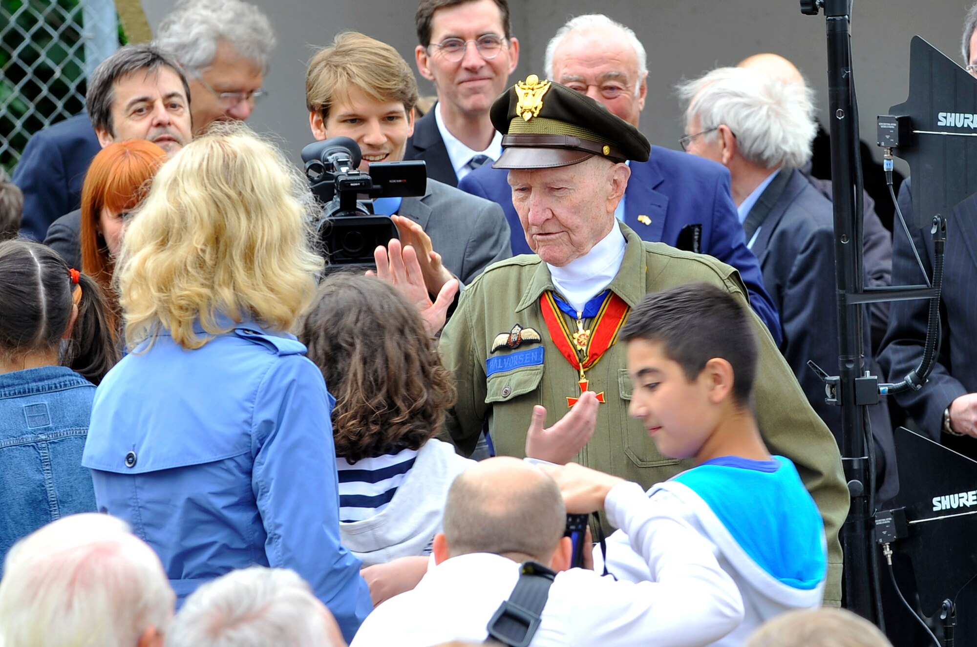 Retired Col. Gail Halvorsen, the “candy bomber”, high-fives members of a school choir after their performance at the commemoration ceremony of the 65th anniversary of the Berlin Airlift, June 26, 2013, Frankfurt, Germany. The members of the youth choir gave Halvorsen candy after their performance as a way to thank him for his actions during the Berlin Airlift. (U.S. Air Force photo/Airman 1st Class Trevor Rhynes)                                                                                                                                               