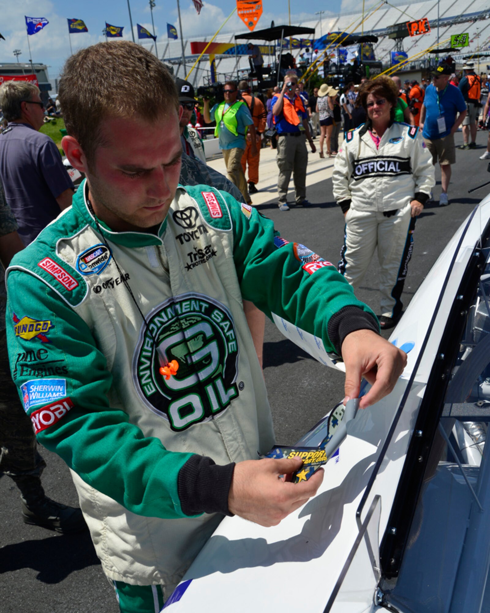A crew member for Mike Bliss, driver of the No. 19 TriStar Motorsports Chevy, places the Support Military Foundation awareness ribbon on the car June 1, 2013, at Dover International Speedway in Dover, Del. The support ribbon is a digital camouflage blend of service colors, one from each branch of the military, inherently representing solidarity and unity in support of all that dedicated service to protect and defend this country. (U.S. Air Force photo/David S. Tucker)