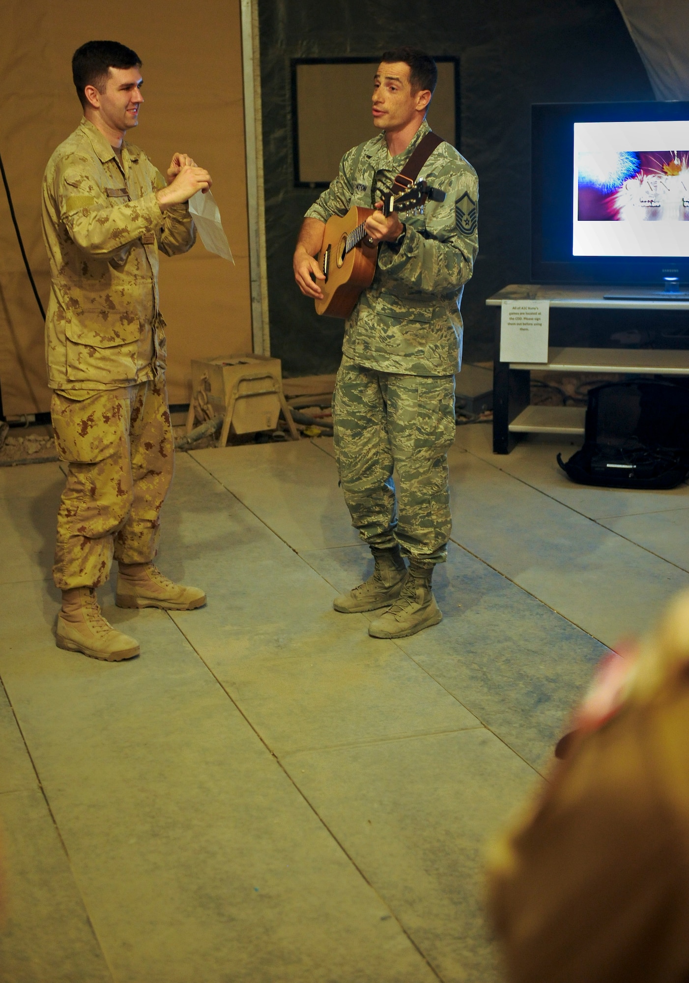 U.S. Air Force Master Sgt. Lou Lanton plays guitar while he sings Canadian-centric songs he wrote especially for the Canada Day celebration held in the Pyramid morale tent at the 379th Air Expeditionary Wing in Southwest Asia, July 1, 2013. Lanton is the U.S. Air Force 71st Expeditionary Air Control Squadron crew superintendent deployed from Hill Air Force Base, Utah. (U.S. Air Force photo/Senior Airman Benjamin Stratton)