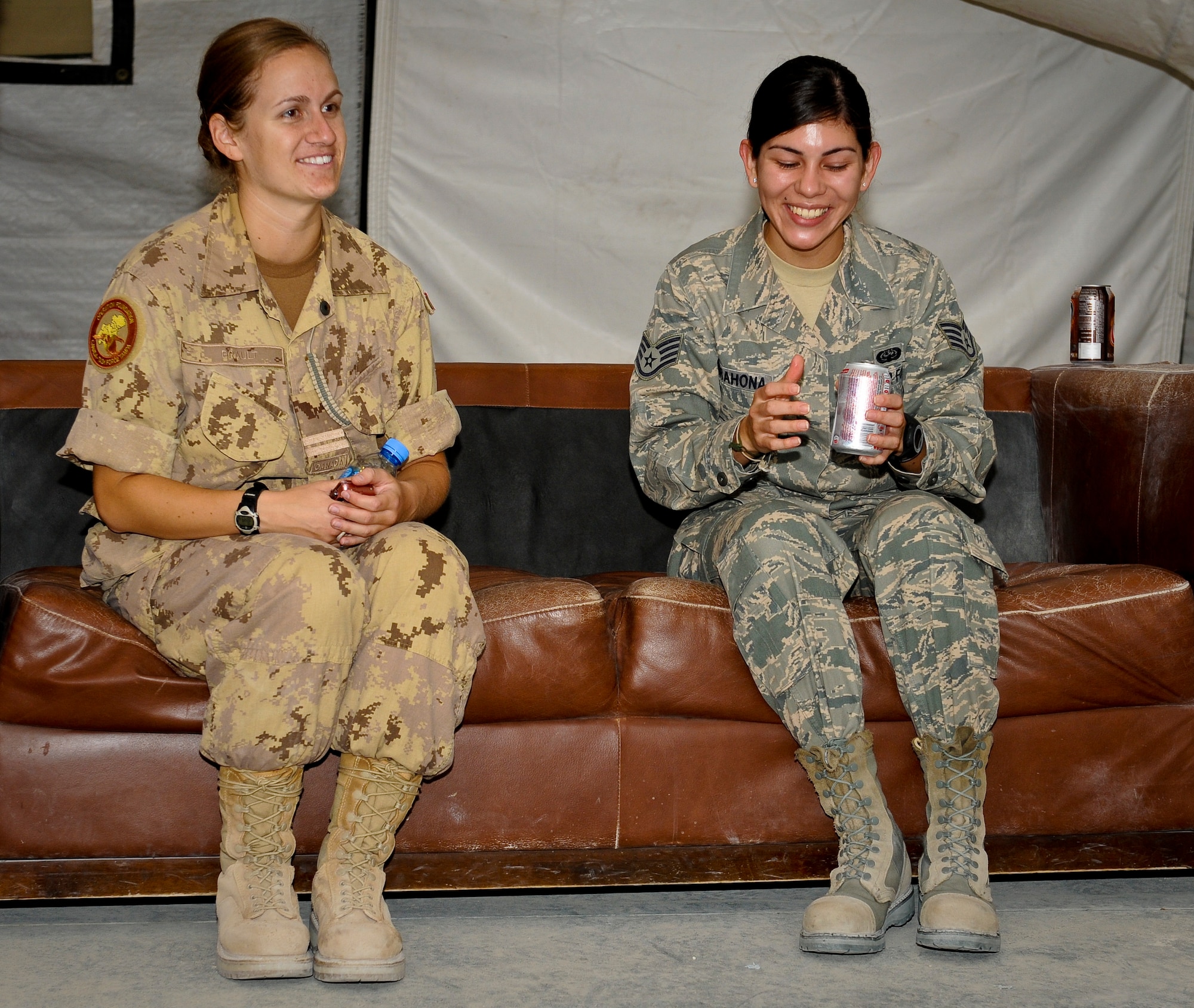 Canadian Air Forces Capt. Alex Brault and U.S. Air Force Staff Sgt. Daniela Barahona share experiences during the Canada Day celebration at the 379th Air Expeditionary Wing in Southwest Asia, July 1, 2013. Brault is the Canadian 71st Expeditionary Air Control Squadron director of operations and Barahona is a U.S. Air Force 71st EACS radio frequency transmission systems technician deployed from Hill Air Force Base, Utah. (U.S. Air Force photo/Senior Airman Benjamin Stratton)