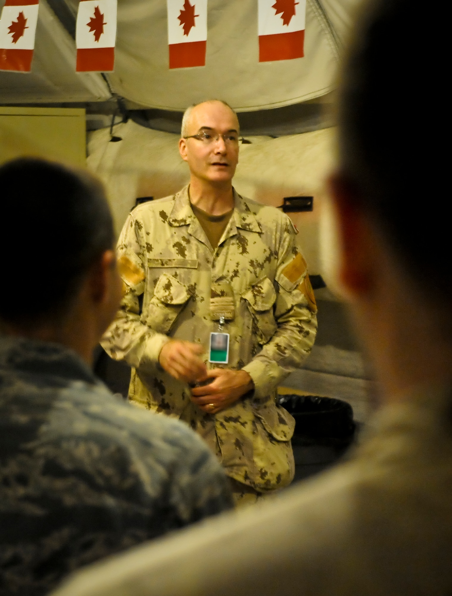Canadian Air Forces Maj. Mike Hagen thanks people for coming to the Canada Day celebration held in the ?Pyramid? morale tent at the 379th Air Expeditionary Wing in Southwest Asia, July 1, 2013. Hagen is the Canadian 71st Expeditionary Air Control Squadron commander. With Canadian flags strung from corner to corner, maple syrup candies on every table, and Canadian paraphernalia at every turn, Canadian, U.S., Australian, coalition and mission partners celebrated Canada?s birthday. (U.S. Air Force photo/Senior Airman Benjamin Stratton)