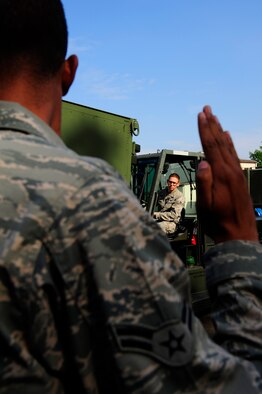 Airman 1st Class Fabio Deavers (left), 86th Vehicle Readiness Squadron vehicle operator, guides Airman 1st Class Kevin Grimm 86th VRS vehicle maintainer toward a trailer to place the pallet onto during a safety stand-down day, June 28, 2013 at Ramstein Air Base, Germany. U.S. Air Forces in Europe and Air Forces Africa units participated in a safety stand-down day to emphasize the importance of MHE safety. (U.S. Air Force photo/Staff Sgt. Travis Edwards)