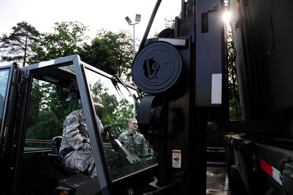 Staff Sgt. Hector Galan (left), 86th Vehicle Readiness Squadron assistant NCO in charge of material handling equipment maintenance, uses a forklift to hoist a pallet from a trailer while Staff Sgt. Matthew Creighton 86th VRS MHE maintainer, spots him during a safety stand-down day, June 28, 2013, at Ramstein Air Base, Germany. U.S. Air Forces in Europe and Air Forces Africa units participated in a safety stand-down day to emphasize the importance of MHE safety. (U.S. Air Force photo/Staff Sgt. Travis Edwards)