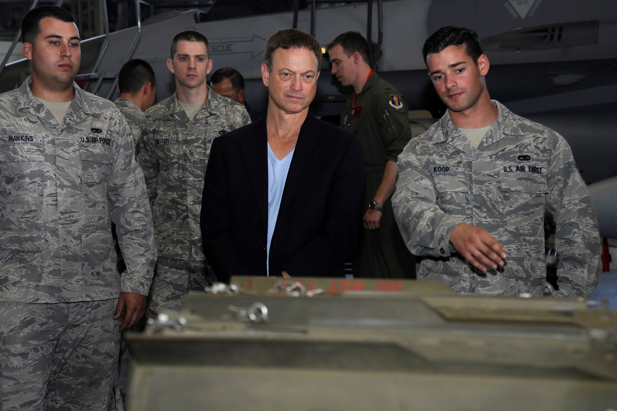 U.S. Air Force Airman 1st Class Kyle Koop, right, 35th Aircraft Maintenance Squadron weapons load crew member, briefs Gary Sinise on different types of munitions used on an F-16 Fighting Falcon during a recent visit to Misawa Air Base, Japan, July 2, 2013. Gary Sinise and the Lt. Dan Band performed for military members and their families as part of a United Service Organizations tour. The USO sends entertainers around the globe to boost morale of service members and their families stationed far from home. (U.S. Air Force photo by Tech. Sgt. Marie Brown)
