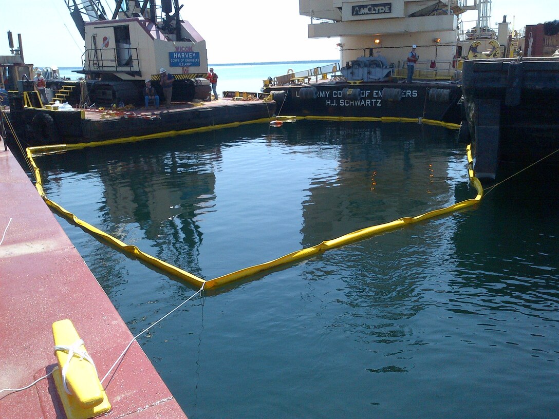 In preparations to raise a tug boat, US Army Corps of Engineers personnel place a boom in the water to prevent any possible oil or contamination leak into the St. Marys River. The USACE tug Hammond Bay unexpectedly sunk while being towed from Duluth, Minn., to Sault Ste. Marie July 1.