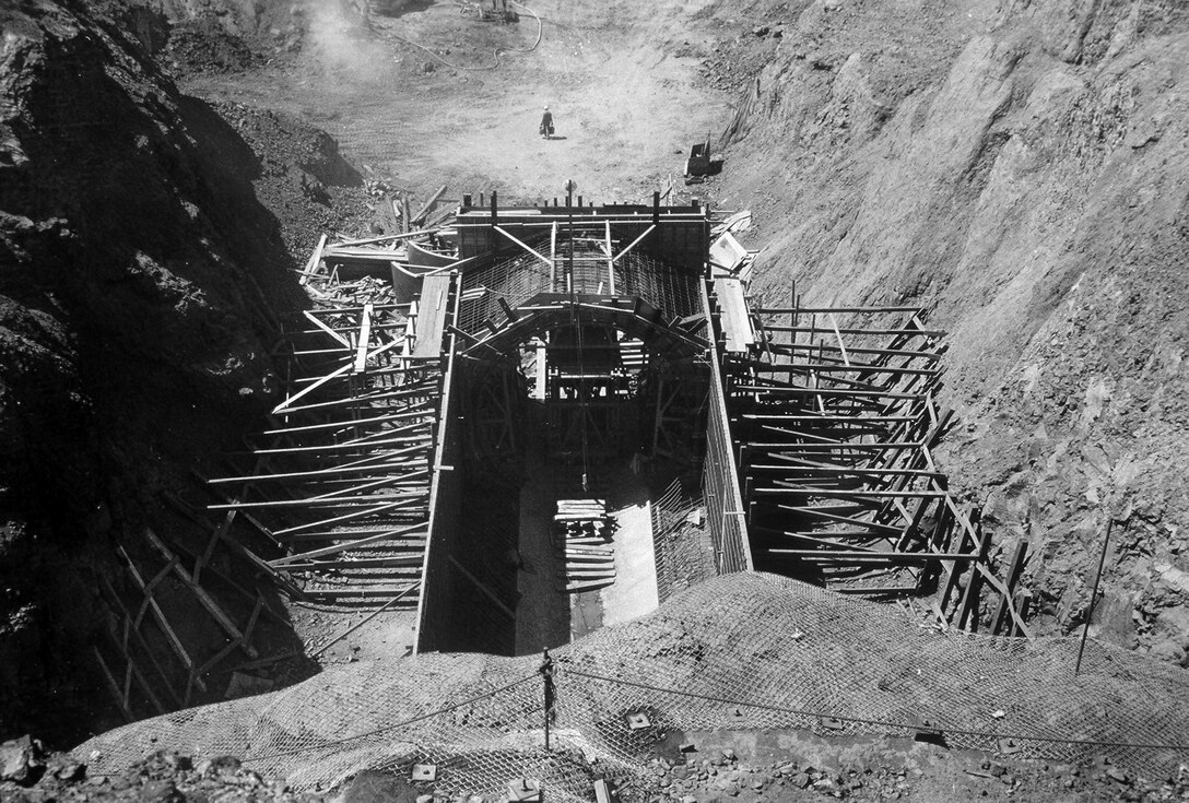 The scale of form work during construction of Black Butte Dam is seen in comparison to the workman in the background.