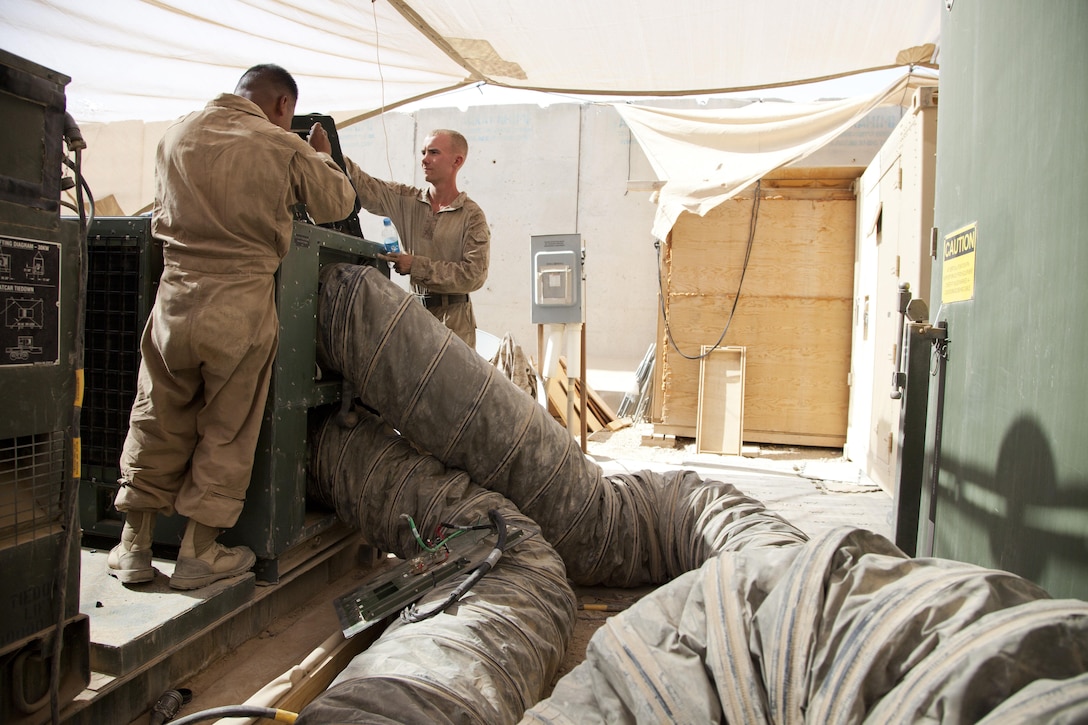U.S. Marines assigned to 3rd Combat Engineer Battalion (CEB), Regimental Combat Team 7, finish replacing a broken air conditioning unit on Camp Leatherneck, Afghanistan, June 23, 2013. The Marines of 3rd CEB are currently deployed to Afghanistan in support of Operation Enduring Freedom. (U.S. Marine Corps photo by Cpl. Alejandro Pena/Released) 