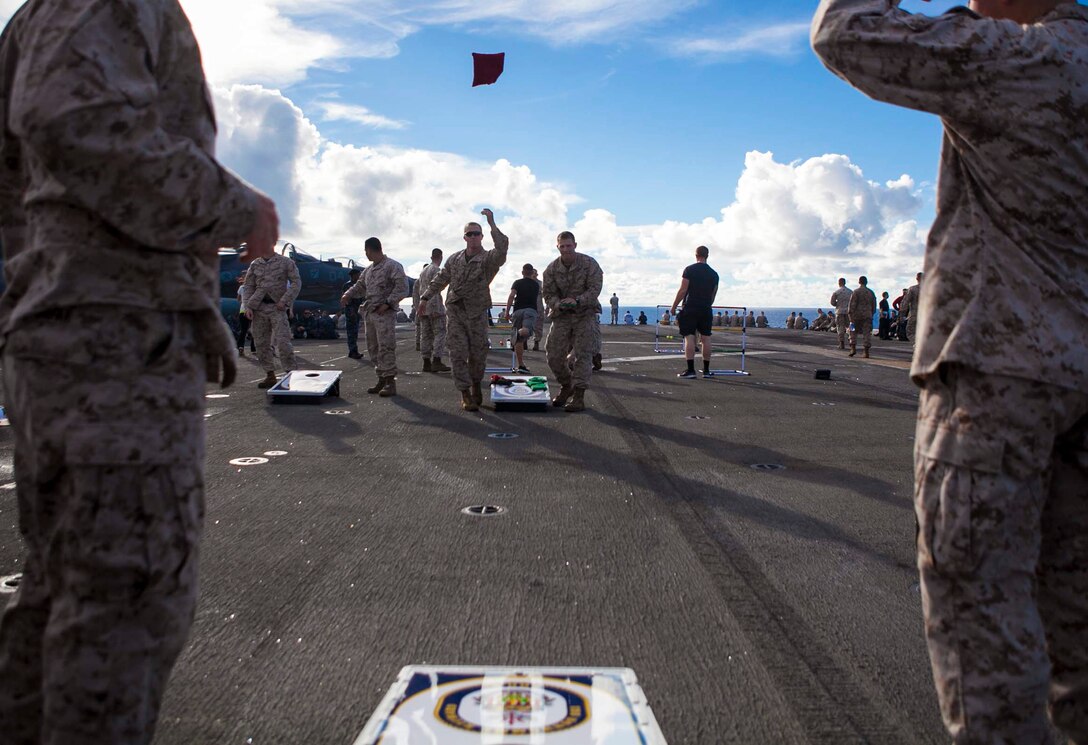 Marines with the 31st Marine Expeditionary Unit play bean bag toss during a steel beach picnic to celebrate Independence Day here, July 4. The “blue and green” team grilled more than 1,300 burgers, 800 pieces of chicken and 800 hotdogs to give the Marines and Sailors a taste of home during the holiday celebration. The 31st MEU is the only continuously forward deployed MEU and is the Marine Corps’ force in readiness in the Asia-Pacific region.