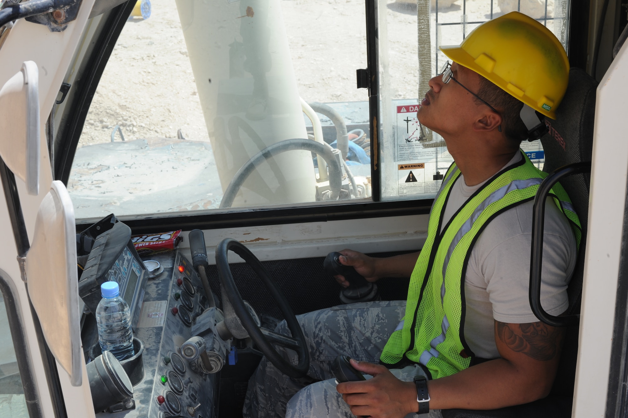 Staff Sgt. Ephraim Advincula operates a crane in the process of replacing an air conditioning unit at the 379th Air Expeditionary Squadron in Southwest Asia, June 28, 2013. The 379th Expeditionary Civil Engineer Squadron horizontal heavy repair Airmen support any 379th AEW mission that requires operating heavy machinery. Advincula is a 379th ECES heavy repair craftsman deployed from Ramstein Air Base, Germany. (U.S. Air Force photo/Senior Airman Bahja J. Jones)