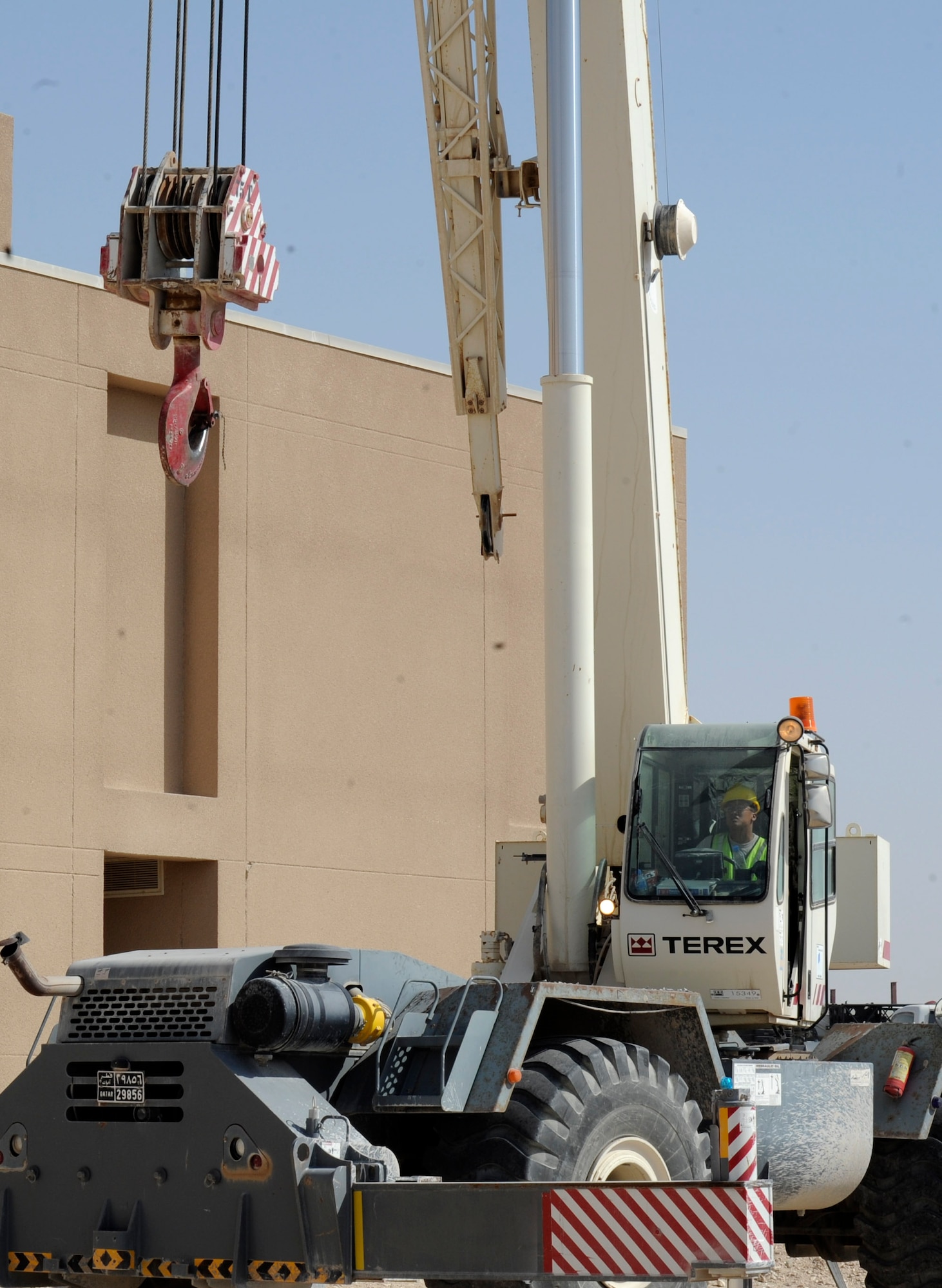 Staff Sgt. Ephraim Advincula operates a crane in the process of replacing an air conditioning unit at the 379th Air Expeditionary Squadron in Southwest Asia, June 28, 2013. The 379th Expeditionary Civil Engineer Squadron horizontal heavy repair Airmen support any 379th AEW mission that requires operating heavy machinery. Advincula is a 379th ECES heavy repair craftsman deployed from Ramstein Air Base, Germany. (U.S. Air Force photo/Senior Airman Bahja J. Jones)
