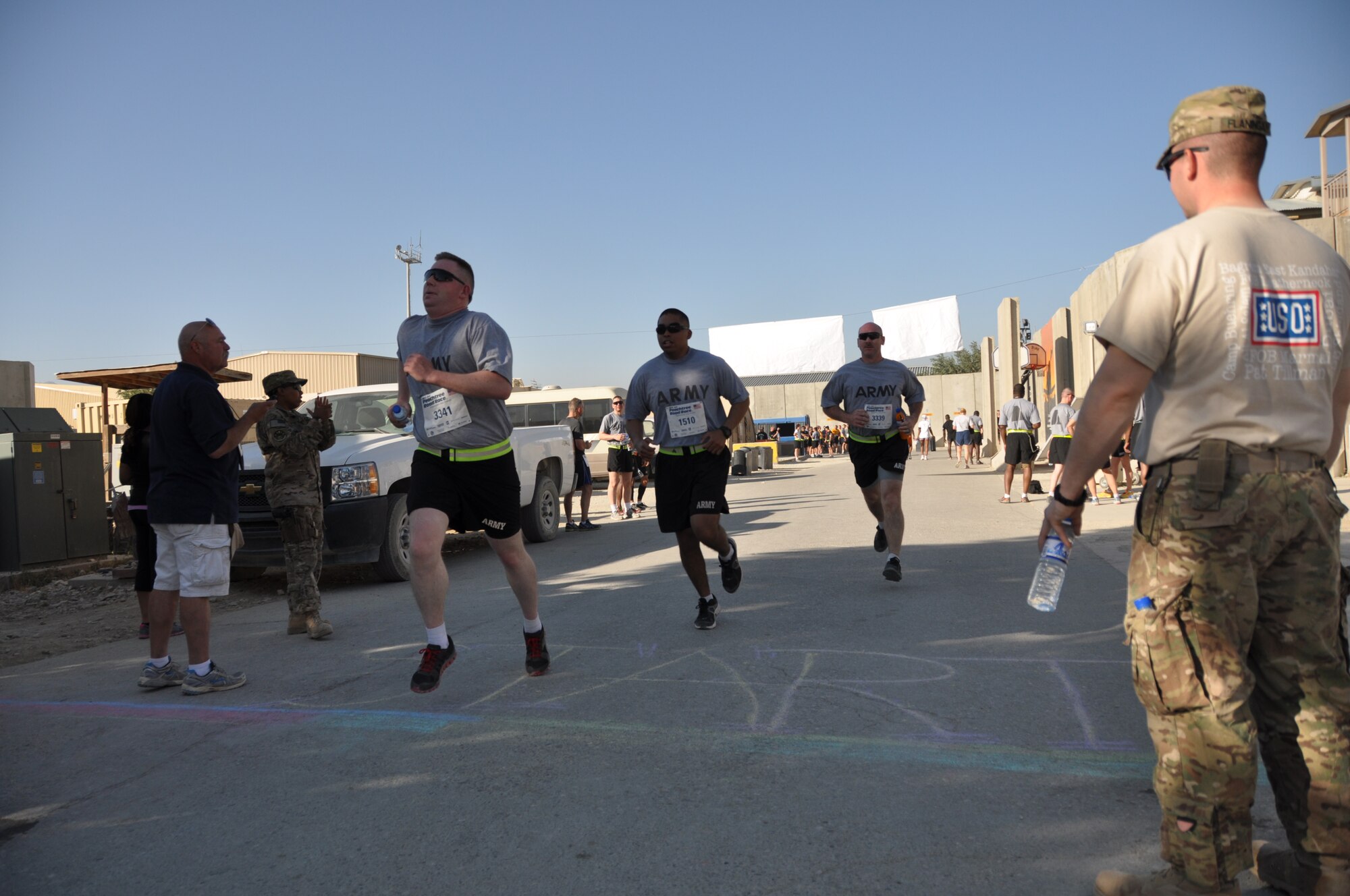 Several runners reach the finish line during an overseas shadow race for the Peachtree 10-kilometer run on Bagram Airfield, Afghanistan, July 4. The morale, welfare and recreation office coordinated with the Atlanta Track Club to hold the road race, which drew more than 600 runners. (U.S. Air Force photo/Tech. Sgt. Rob Hazelett)