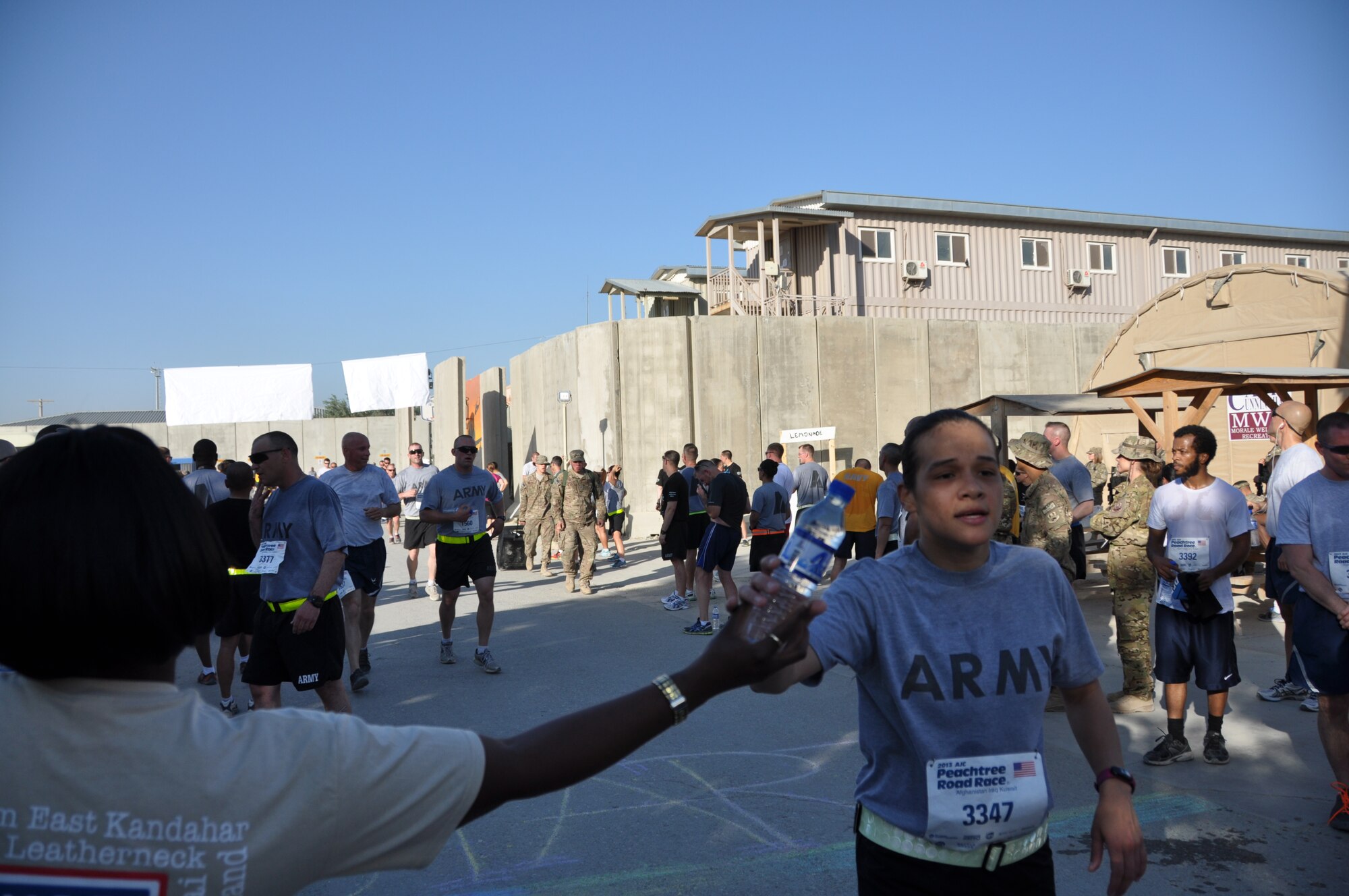A runner crosses the finish line during an overseas shadow race for the Peachtree 10-kilometer run on Bagram Airfield, Afghanistan, July 4. The morale, welfare and recreation office coordinated with the Atlanta Track Club to hold the road race, which drew more than 600 runners. (U.S. Air Force photo/Tech. Sgt. Rob Hazelett)