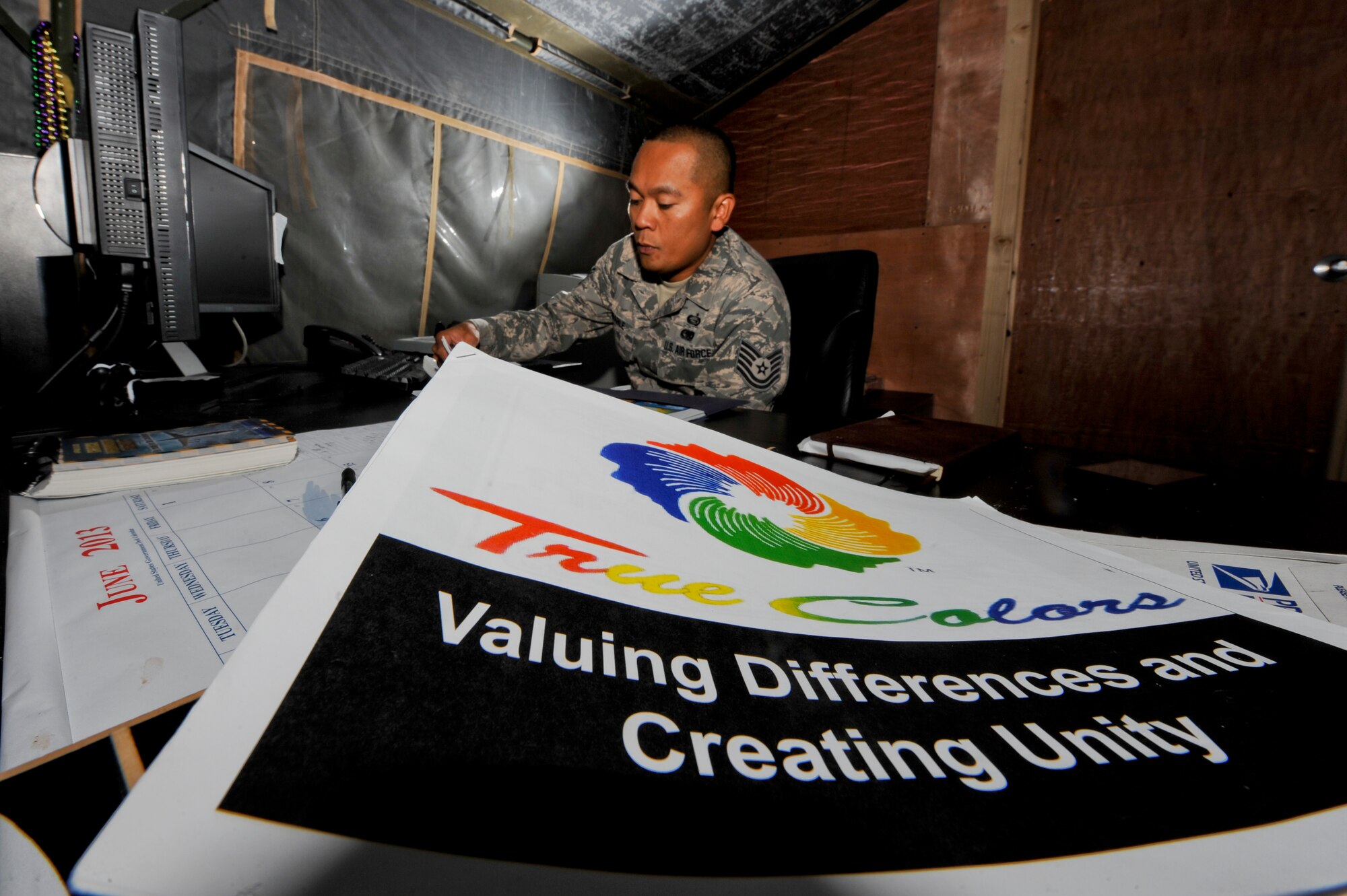A copy of True Colors, a training tool used to educate personnel about differences in personality types, sits in front of U.S. Air Force Tech. Sgt. Adonis Cabarle, 380th Air Expeditionary Wing Equal Opportunity director, at an undisclosed location in Southwest Asia July 1, 2013. Cabarle uses the True Colors program to help members of the 380th AEW create unity in the work environment. Cabarle is native to the Philippines and is deployed from Tyndall Air Force Base, Fla. (U.S. Air Force photo by Staff Sgt.  Joshua J. Garcia)