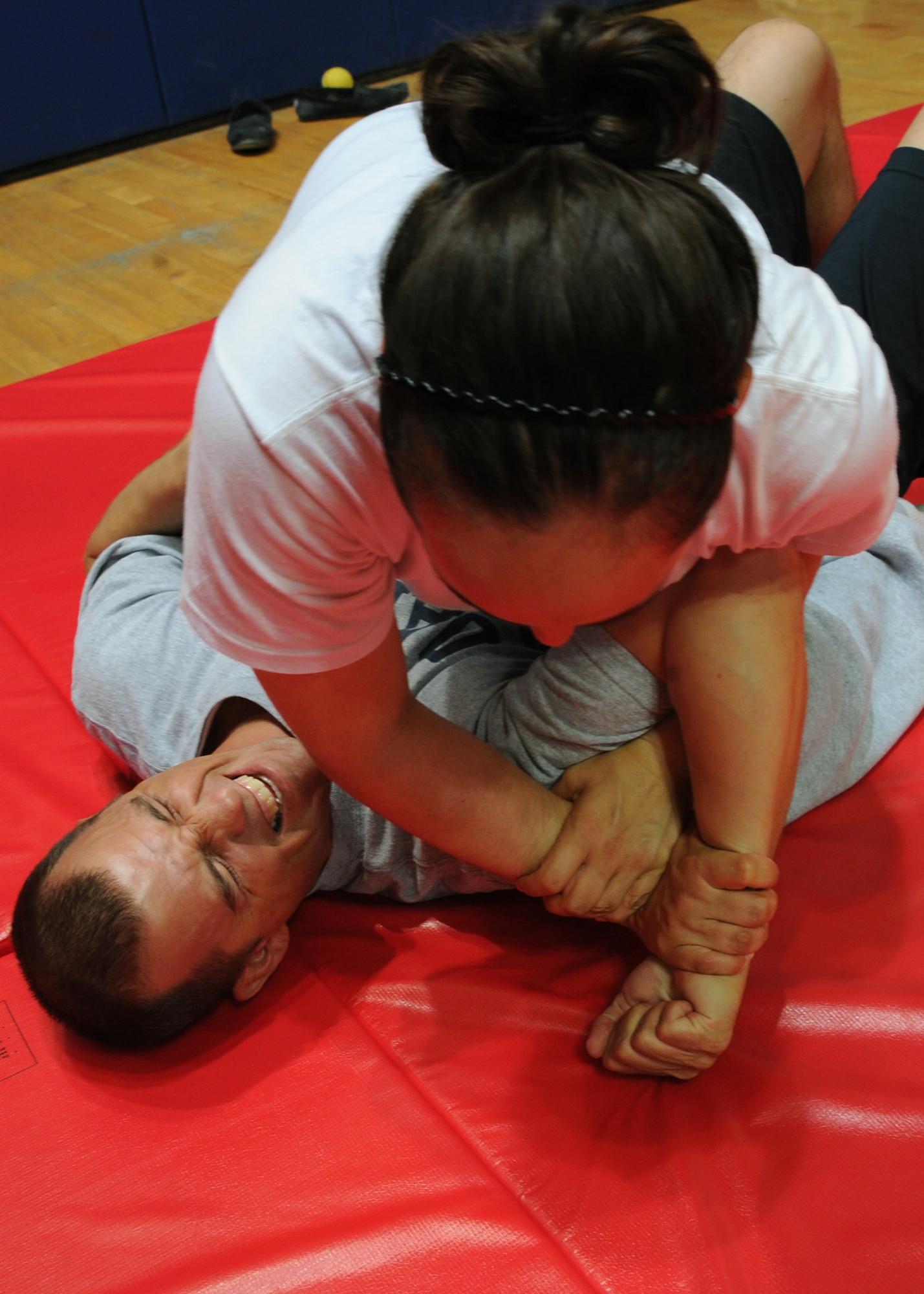 Senior Airman Shannon Holland places Master Sgt. Christopher Knabe in an arm-bar during a Check Six combatives course at the 379th Air Expeditionary Wing in Southwest Asia, June 28, 2013. Holland is a 379th Expeditionary Civil Engineer Squadron third-country national escort deployed from Tinker Air Force Base, Okla., and Knabe is the 379th AEW Force Protection superintendent deployed from Misawa Air Base, Japan. (U.S. Air Force photo/Senior Airman Bahja J. Jones) 