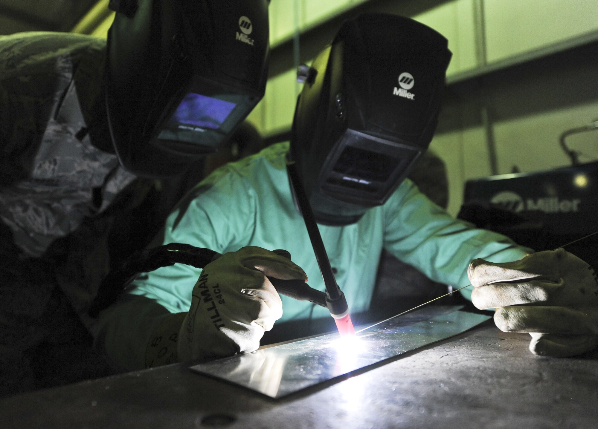 U.S. Air Force Master Sgt. Joseph Harrell, 380th Expeditionary Maintenance Squadron Fabrication Flight chief, left, watches and guides Cadet Matt Waddell in his first welding experience at an undisclosed location in Southwest Asia June 27, 2013. Waddell was visiting the 380th Air Expeditionary Wing as part of the Air Force Academy’s Deployed Operations program. (U.S. Air Force photo by Senior Airman Jacob Morgan)