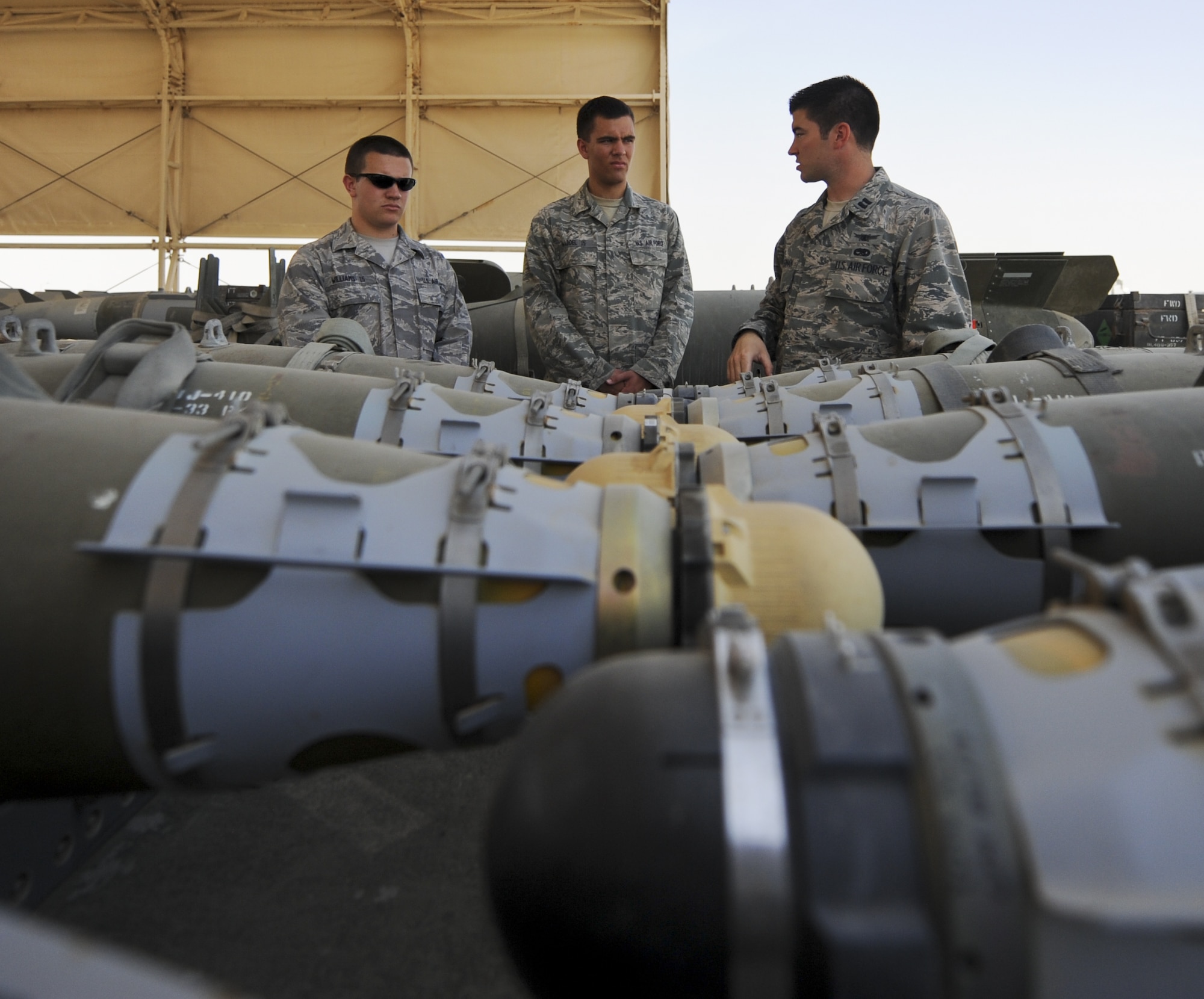 Capt. Patrick Kellerman, right, 380th Expeditionary Maintenance Squadron Munitions Flight officer in charge, explains the different type of guided bombs the 380th EXMS build and maintain to Cadet Robert Williams, left, and Cadet Matt Waddell at an undisclosed location in Southwest Asia June 27, 2013. Waddell and Williams were visiting the 380th Air Expeditionary Wing as part of the Air Force Academy’s Deployed Operations program. (U.S. Air Force photo by Senior Airman Jacob Morgan)