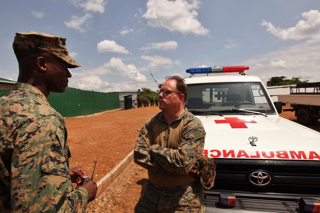 U.S. Navy Hospital Corpsman 1st Class Brent Pope, right, Special-Purpose Marine Air-Ground Task Force (MAGTF) Africa corpsman from Big Piney, Wyo., speaks with Marine Corps Capt. Dax Verdia in between training engagements at the Peace Support Operations Training Center-Singo in Kakola, Uganda, June 24, 2013. Pope is currently deployed with Special-Purpose MAGTF Africa and recently completed a logistics focused engagement with Uganda People’s Defense Force (UPDF) soldiers who will deploy to Somalia later this year. Since deploying in January, Special-Purpose MAGTF Africa has trained more than 800 African service members, including 310 UPDF soldiers. (U.S. Marine Corps photo by 2nd Lt. Andrew Bolla/Released)