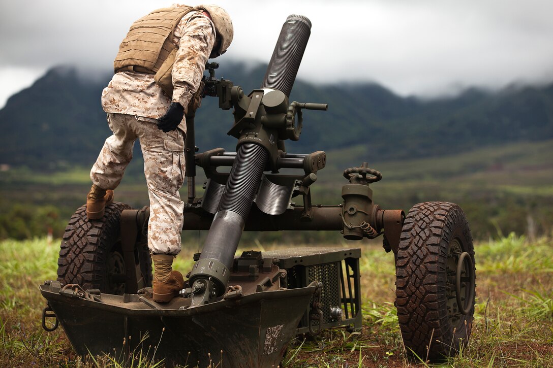 Sgt. Terry Lott, a cannoneer with Bravo Battery, 1st Battalion, 12th Marine Regiment, aims their M327 Towed Rifle mortar firing system in preparation for a live fire exercise at Schofield Barracks, June 25, 2013. In an effort to aim the mortar systems precisely, forward observers draw azimuths to match up their firing coordinates with the same coordinates the mortar systems are aimed. (U.S. Marine Corps photo by Lance Cpl. Matthew Bragg)