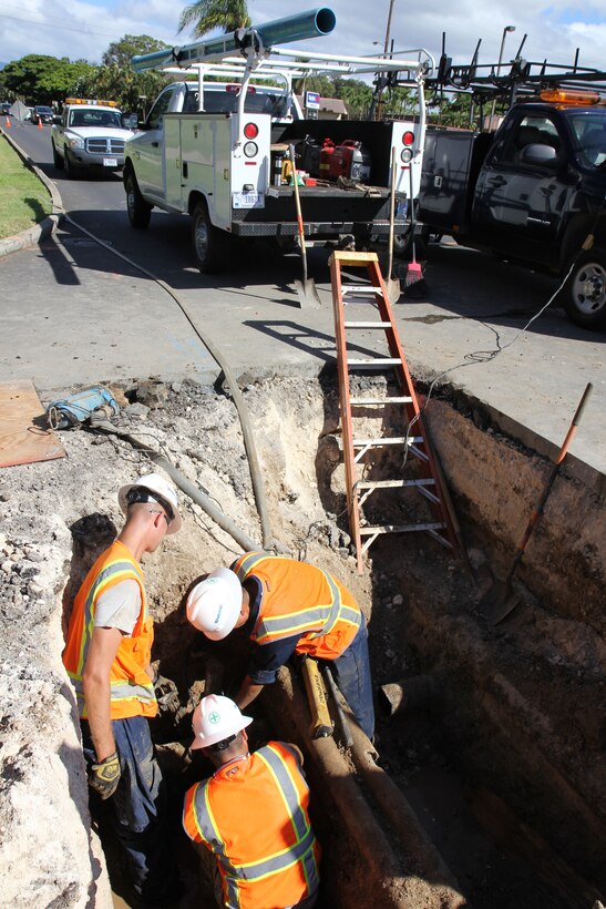 From left clockwise, Tech. Sgt. Benjamin M. Johnson, a plumber with the 647th Civil Engineering Squadron, and Airman 1st Class Robert T. Shikina and Senior Airman Tito M. Irlas plumbers with the 624th Civil Engineering Squadron, position a snap cutter on a water main pipe in order to remove the broken pipe and repair a leak, Joint Base Pearl Harbor-Hickam, Hawaii, June 27, 2013. Communication lines, center, can be seen running over the water main, as well as an abandoned fuel line, to the far right, creating obstacles. (U.S. Air Force photo by Tech. Sgt. Phyllis E. Keith)