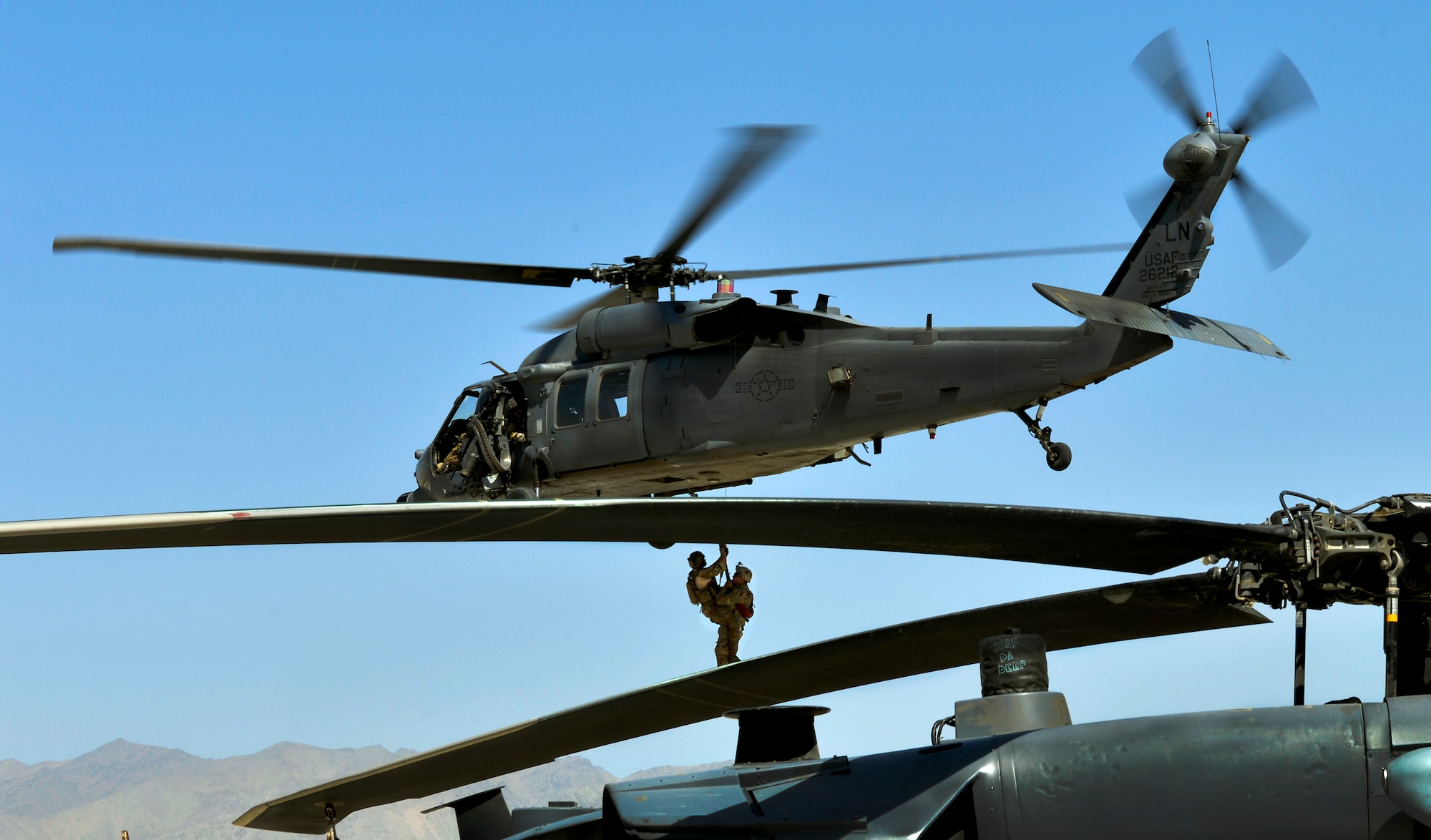 U.S. Army tactical explosive detection dogs and their handlers take turns getting hoist into a HH-60G Pave Hawk helicopter by 83rd Expeditionary Rescue Squadron pararescueman during joint training at Bagram Airfield, Afghanistan, June 21.  The TED dogs are trained to find IED’s outside the base. The chances of them needing rescued are high here making this training important for both branches. (U.S. Air Force photo/ Staff Sgt. Stephenie Wade)