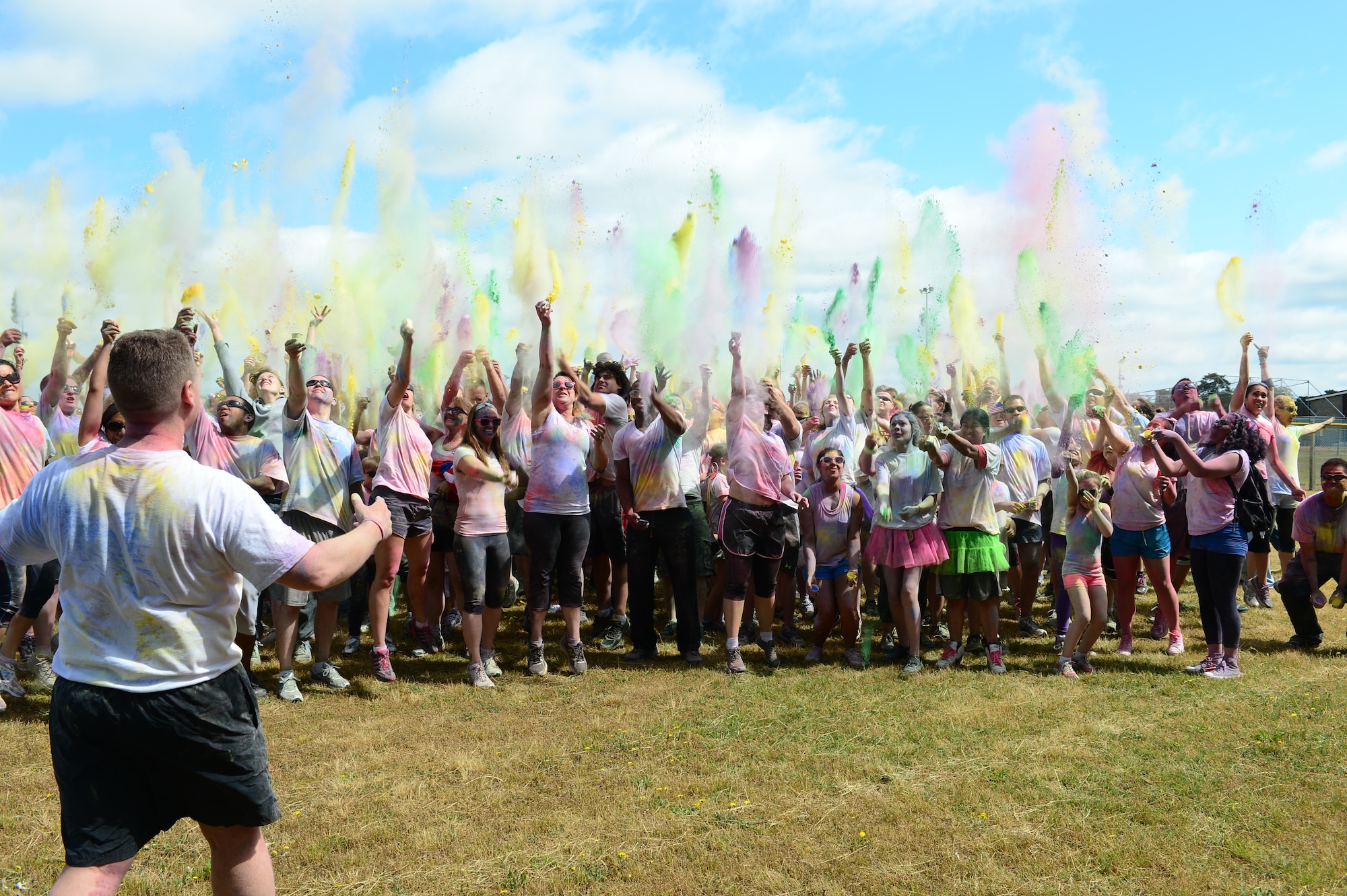 ROYAL AIR FORCE LAKENHEATH, England – Color run participants throw powder paint in the air to celebrate the end of the run July 4, 2013. More than 400 families participated in the color run to help raise money for the upcoming Air Force Ball in September. (U.S. Air Force photo by Airman 1st Class Dana Butler)
